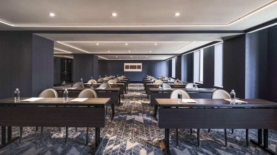 a conference room with tables and chairs at The First