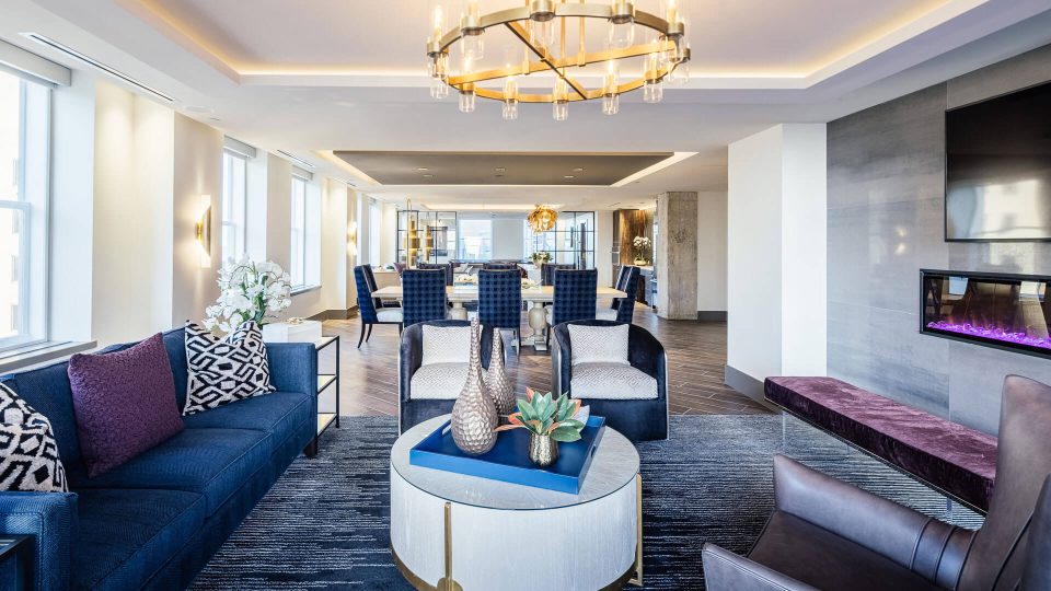 the living room has blue couches and a fireplace at The First