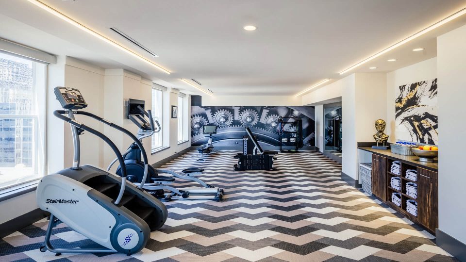 a gym room with treads and exercise equipment at The First