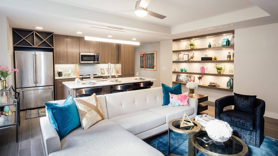 a living room with a couch, coffee table and a television at The First