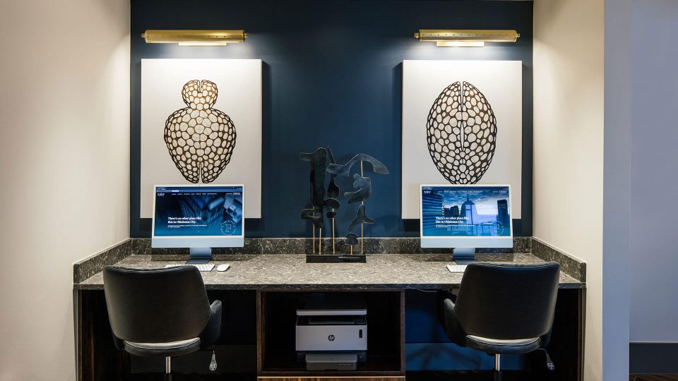 a home office with two computers and two paintings at The First