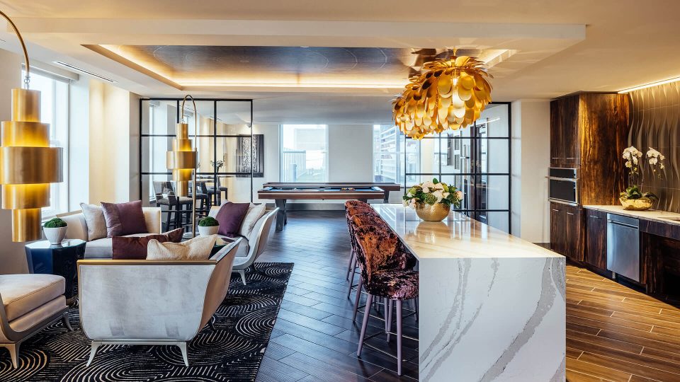 the living room of a modern apartment with a large table and chairs at The First