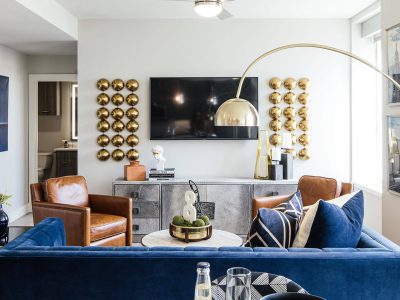 a living room with blue couches and a large flat screen tv at The  First