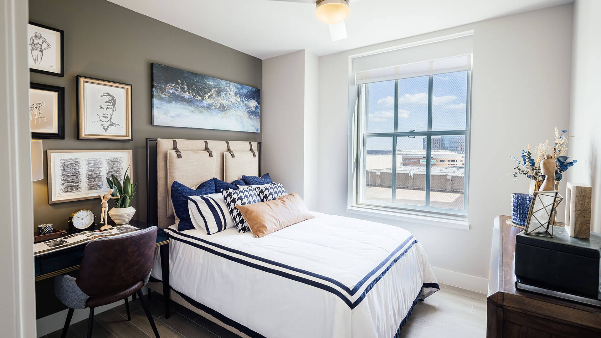 a bedroom with a bed, desk, and pictures on the wall at The  First