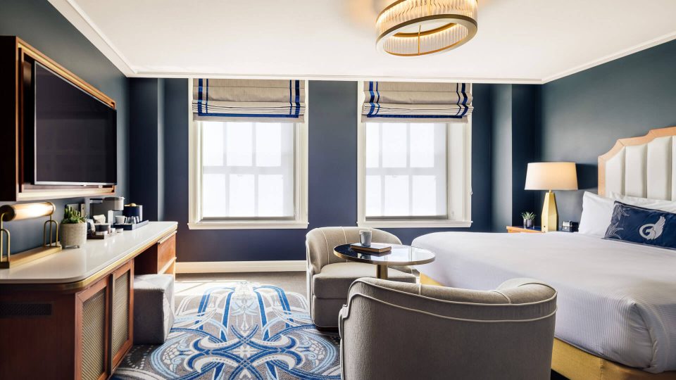 a hotel room with blue walls and a bed at The First