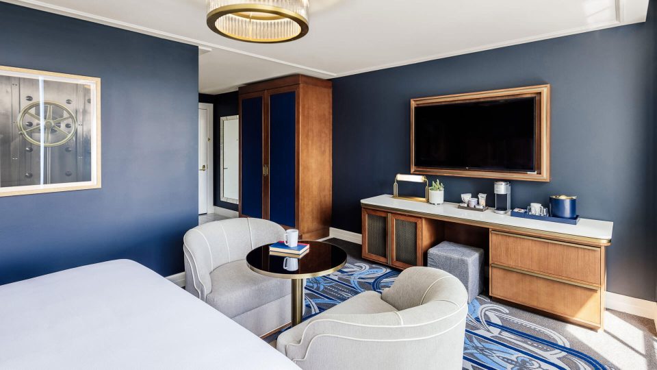 a hotel room with blue walls and a television at The First
