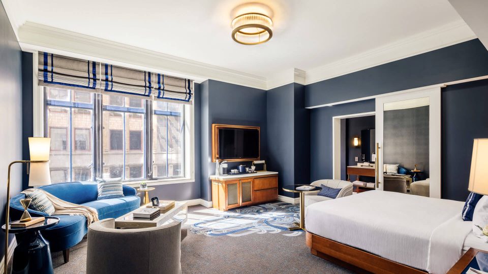 a hotel room with blue walls and a large bed at The First