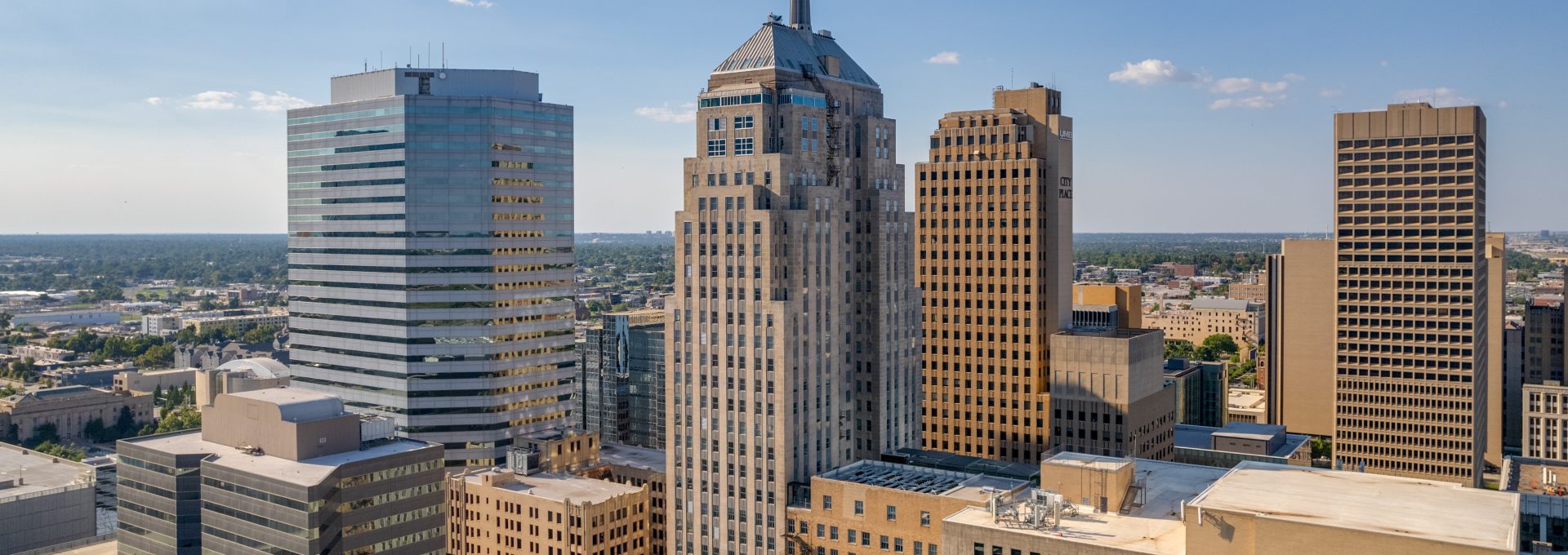 a city skyline with tall buildings and a blue sky at The  First