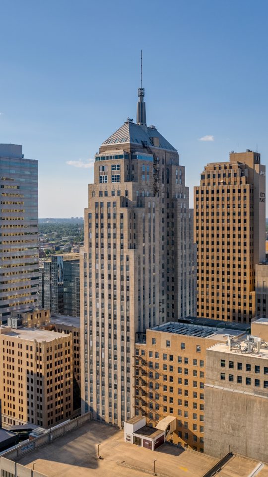 a city skyline with tall buildings and a blue sky at The  First