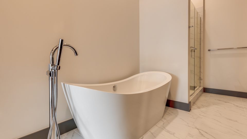 a bathroom with a bath tub and shower stall at The First