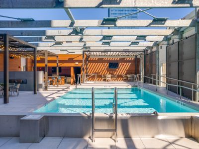 a pool with a sun roof and a patio at The  First