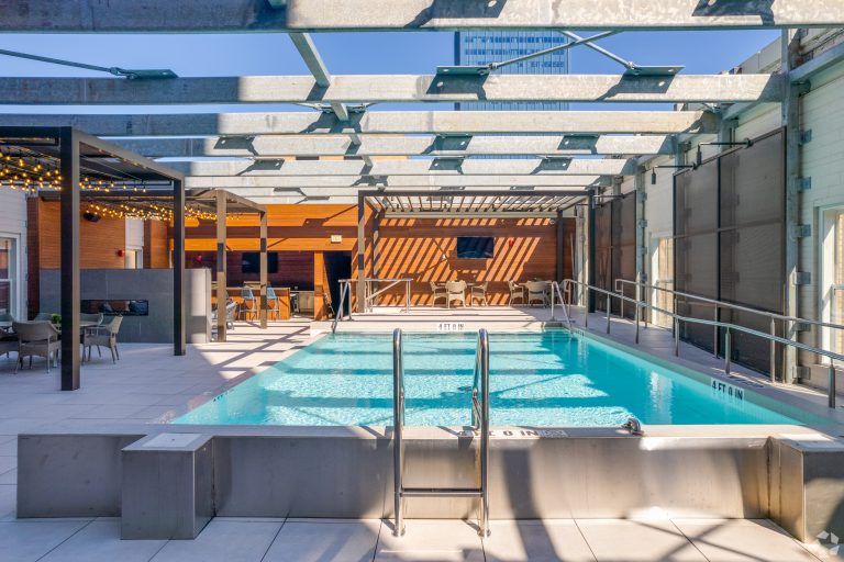 a pool with a sun roof and a patio at The  First