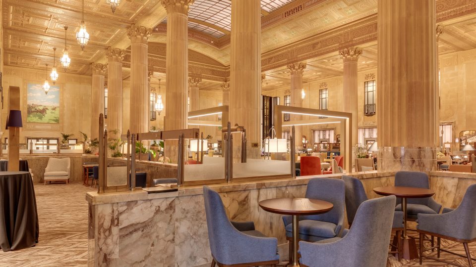 the lobby of a hotel with blue chairs and tables at The First
