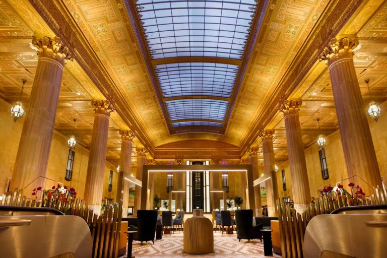 the lobby of a hotel with a large ceiling at The  First