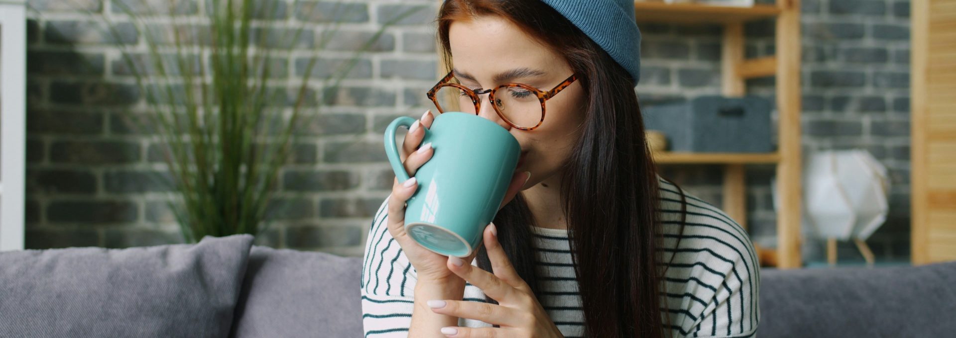 A woman enjoying a warm drink at home