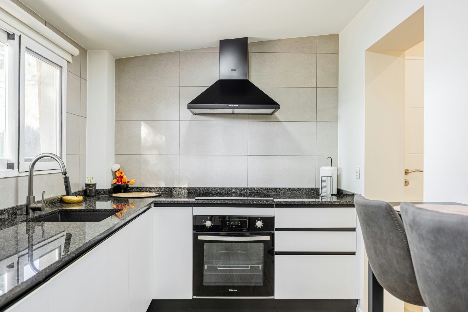 Apartment kitchen with white cabinets and modern appliances