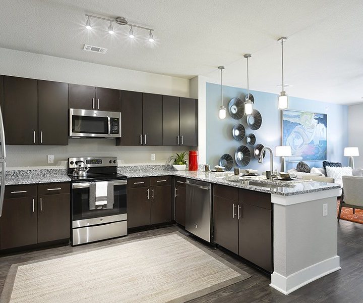 a kitchen with stainless steel appliances and wood floors at The Watson