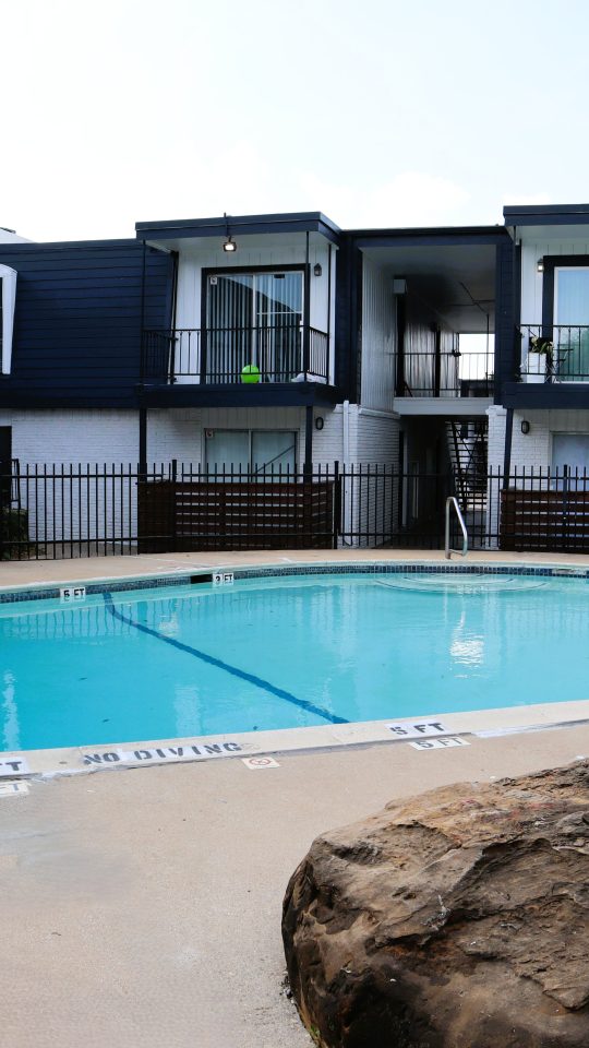 a swimming pool with a tennis court next to it
