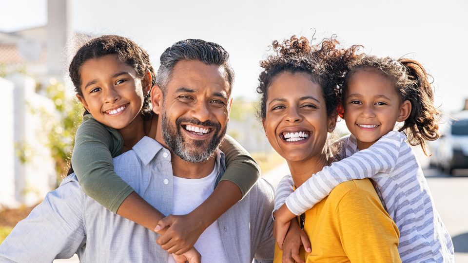 a family is smiling and holding each other at The Breezeway Townhomes