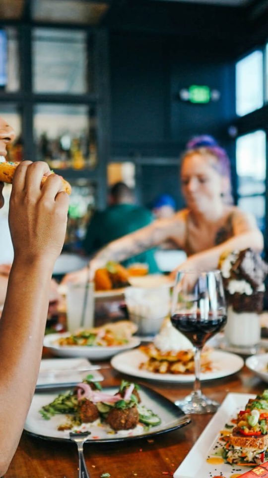 people eating food at a restaurant table at The Breezeway Townhomes