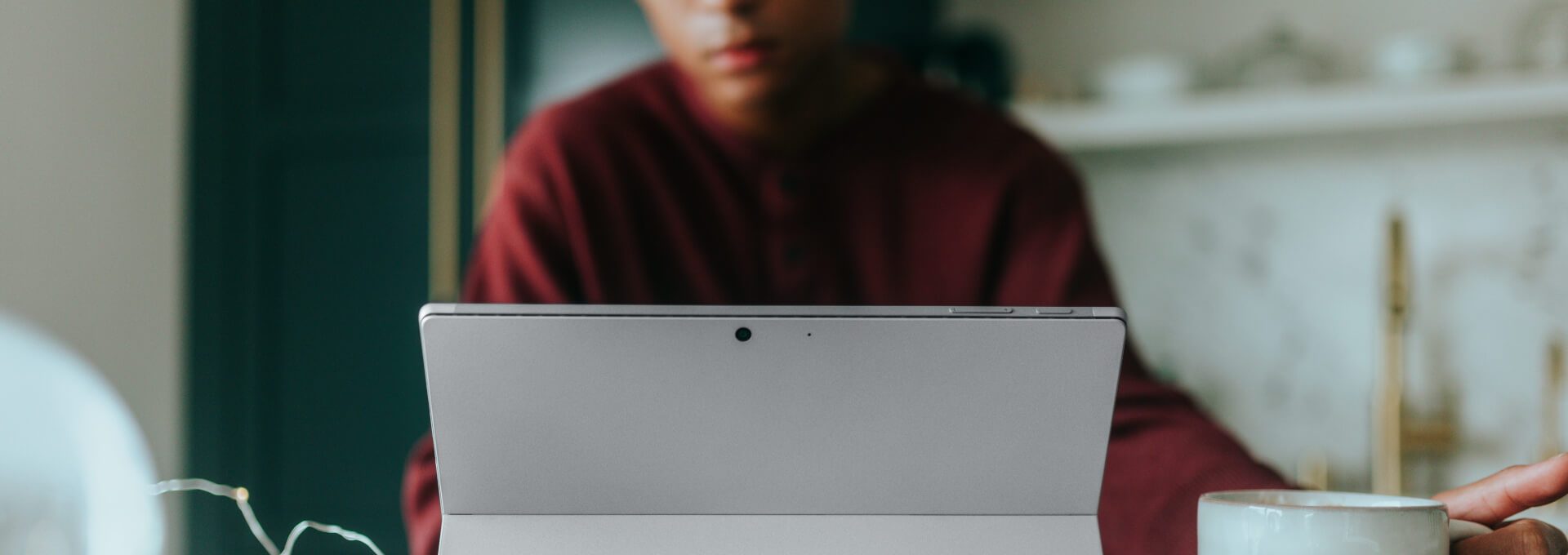 a woman is using a surface laptop in her kitchen at The Breezeway Townhomes