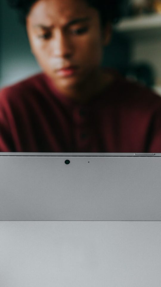 a woman is using a surface laptop in her kitchen at The Breezeway Townhomes