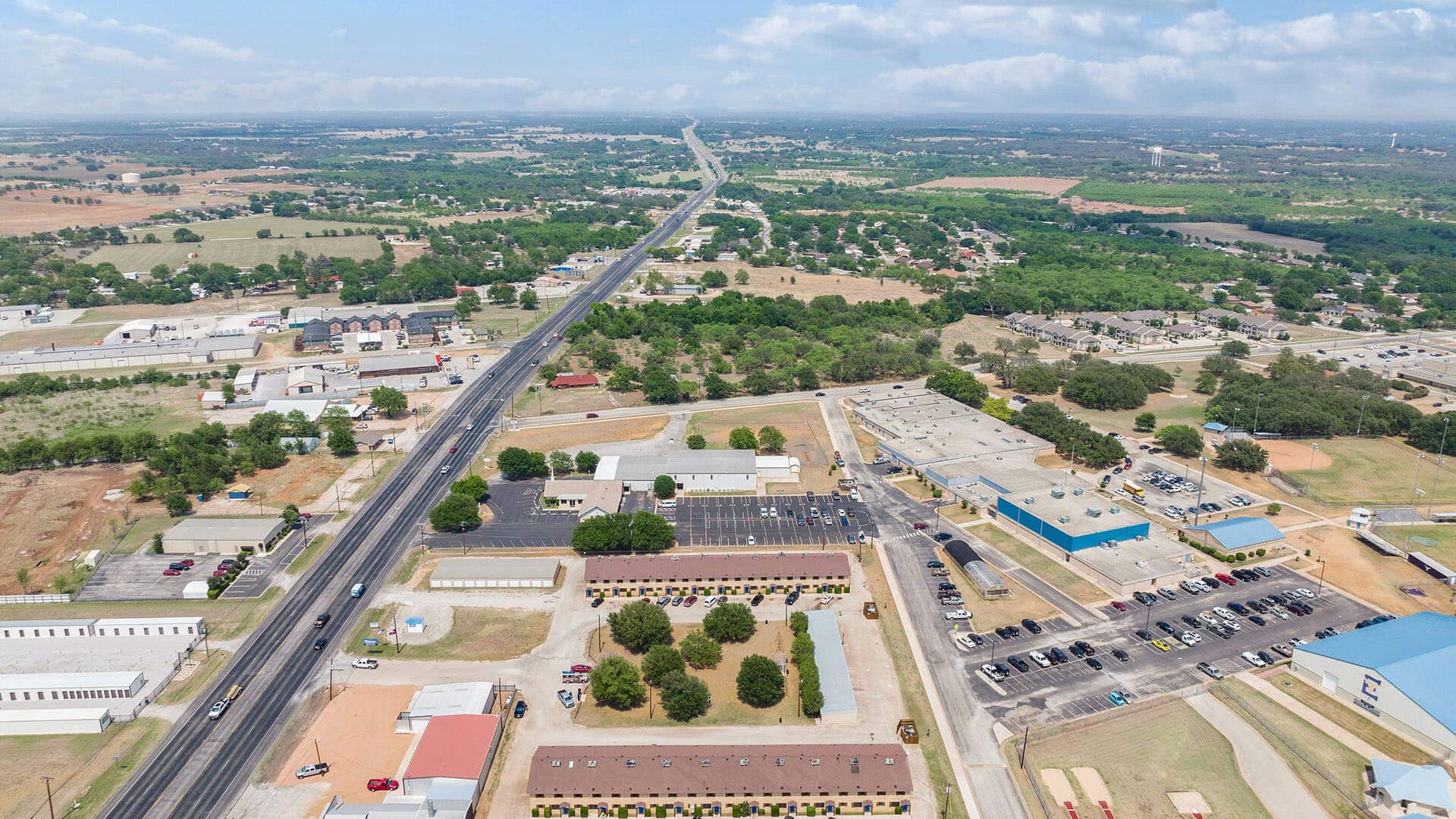 aerial view of a large industrial area with a highway at The Breezeway Townhomes