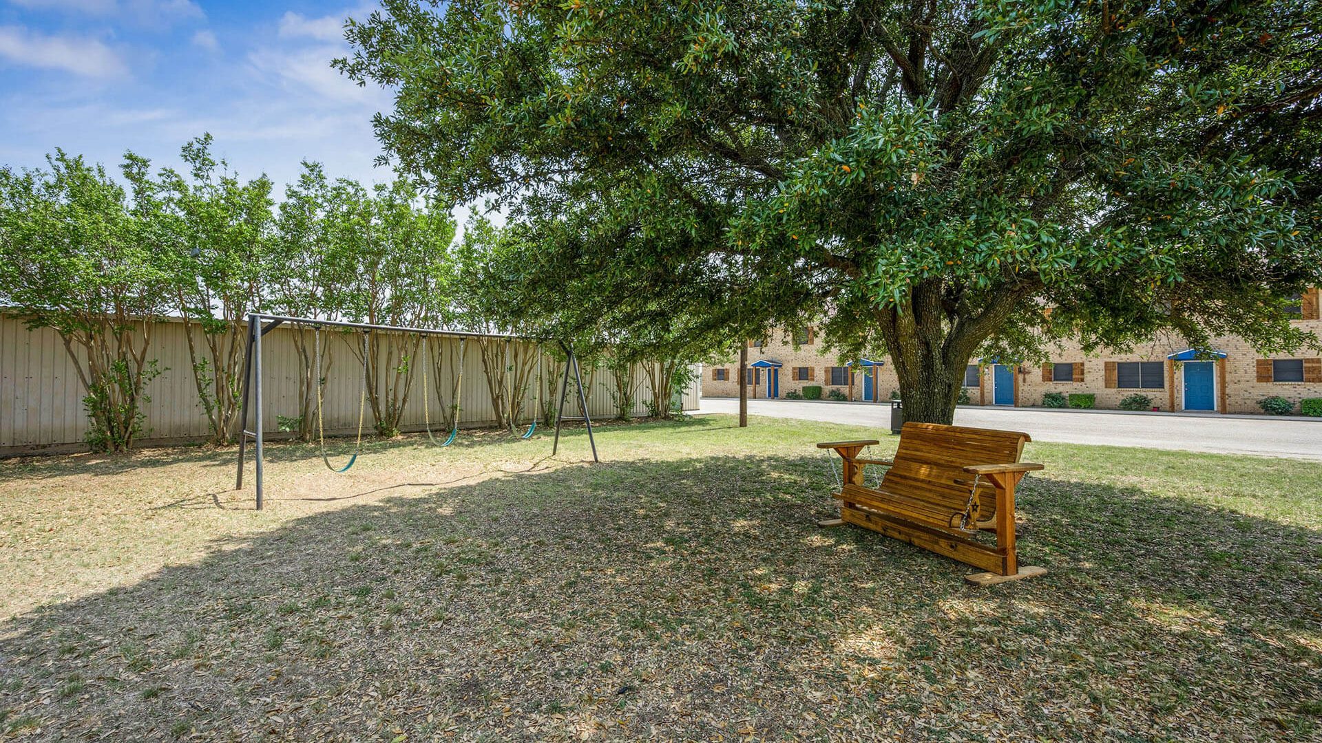a bench in the yard next to a tree at The Breezeway Townhomes
