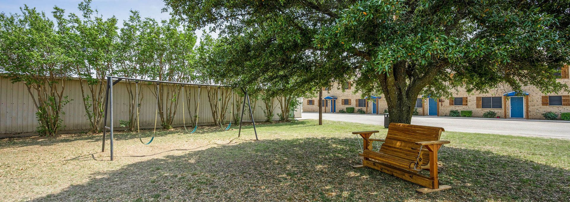 a bench in the yard next to a tree at The Breezeway Townhomes