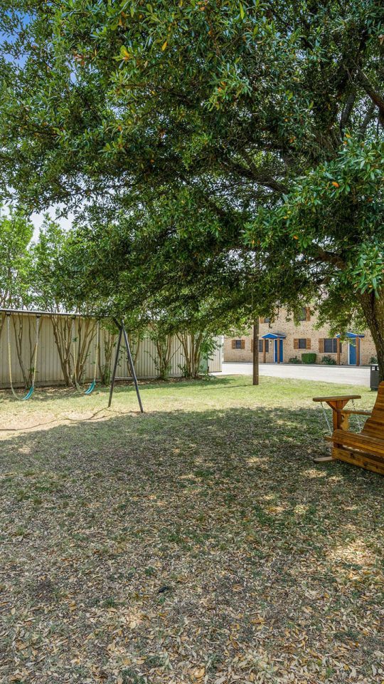 a bench in the yard next to a tree at The Breezeway Townhomes