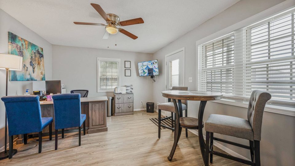 a room with a table, chairs and ceiling fan at The Breezeway Townhomes