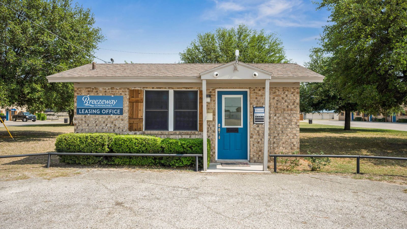 a small building with a blue door and a sign that says, at The Breezeway Townhomes