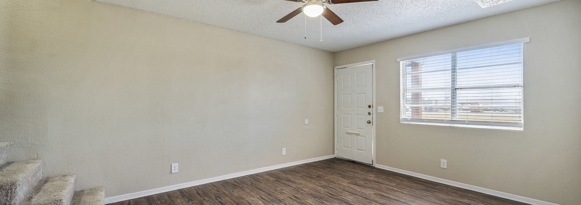 empty room with hardwood floors and ceiling fan at The Breezeway Townhomes