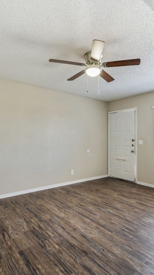 empty room with hardwood floors and ceiling fan at The Breezeway Townhomes