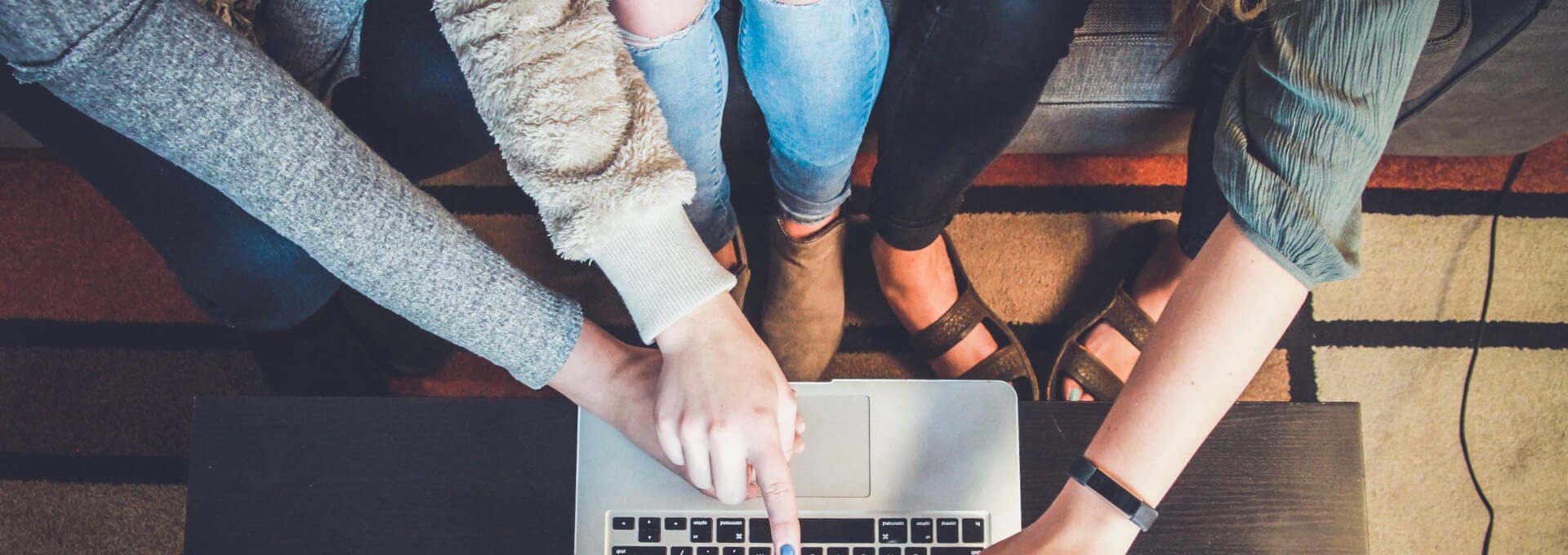 people gathered around a laptop