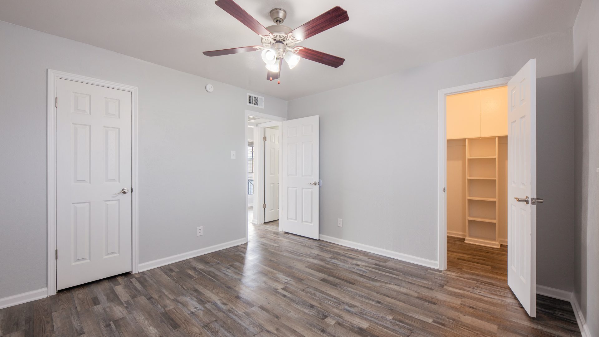 bedroom grey walls brown vinyl plank floors ceiling fan