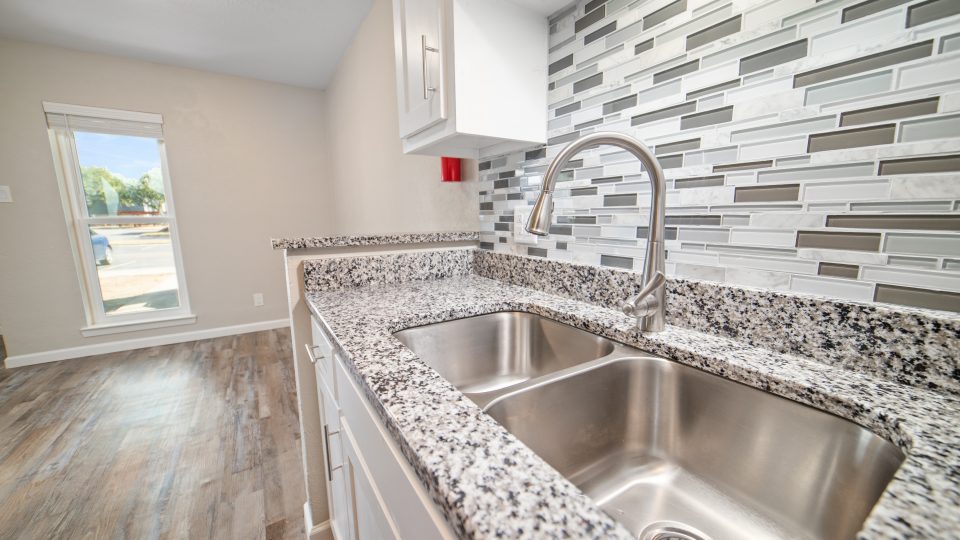 a kitchen with a sink and stainless steel counter tops at The  Magnolia on 4th