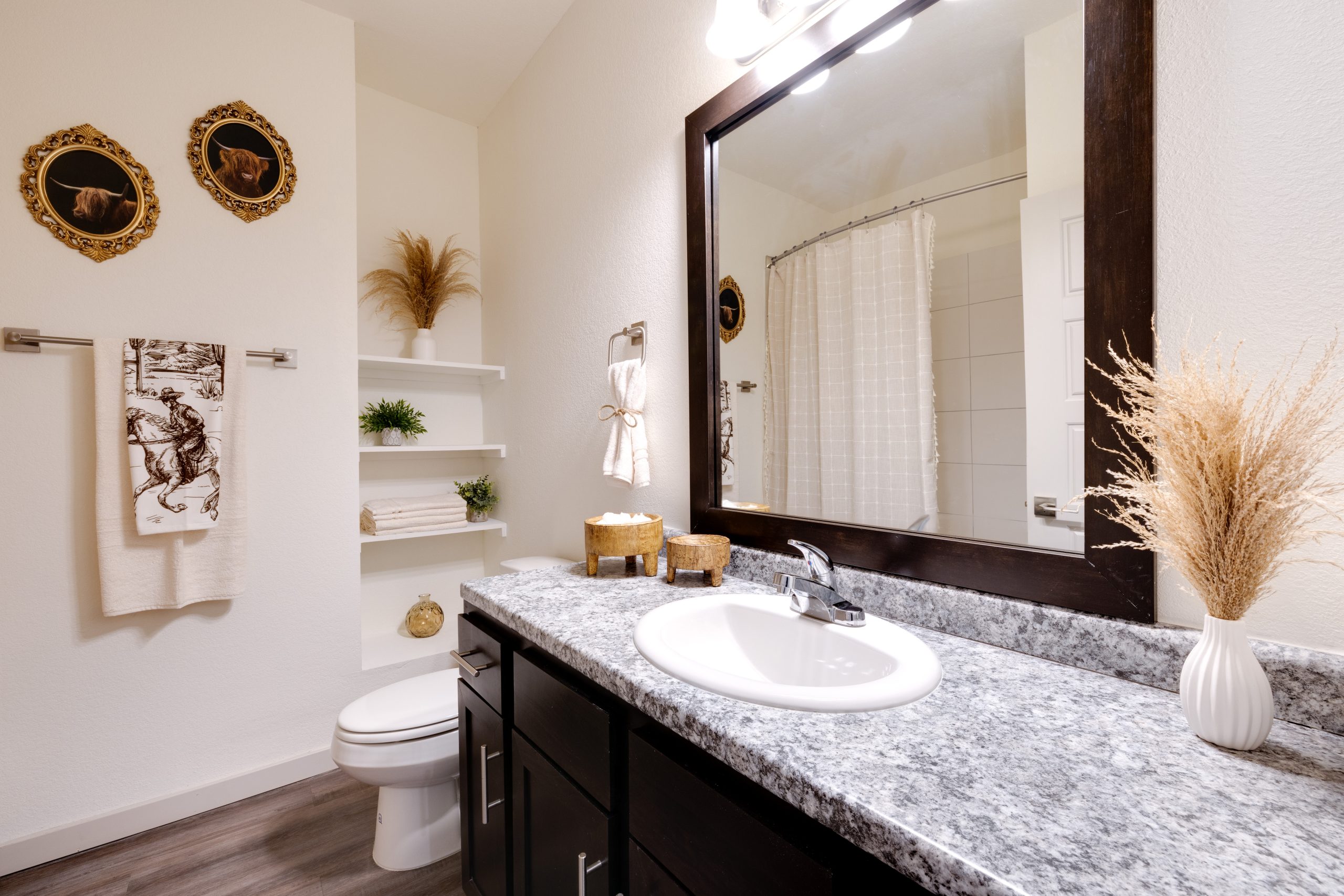 One-Bedroom Apartments in Boerne, TX - Garden Creek Apartments - Bathroom with Built-In Shelves, Garden-Style Tub with Tiled Walls, and a Large Vanity