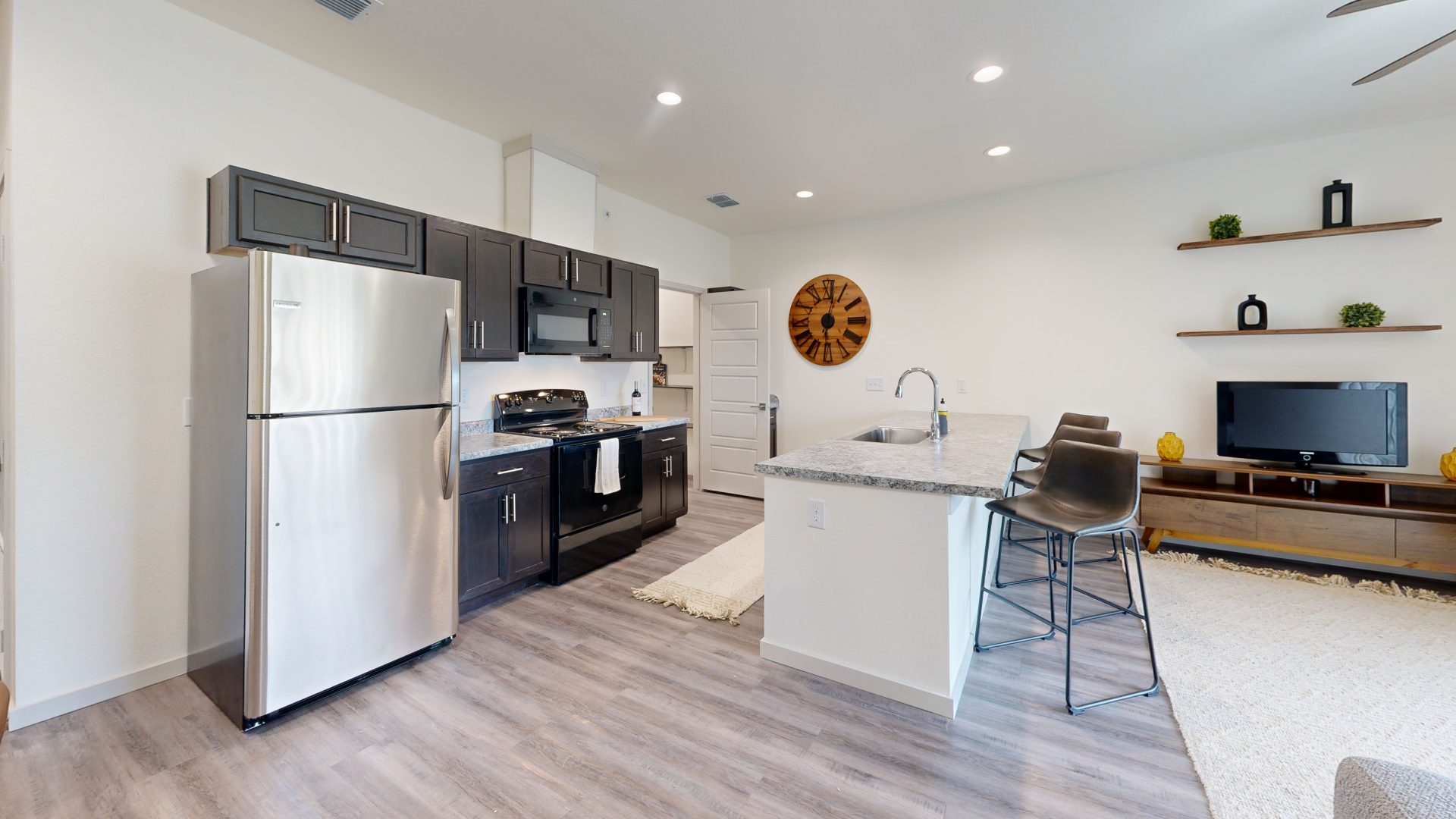 a kitchen with a refrigerator, stove, microwave and sink at The Garden Creek Apartments