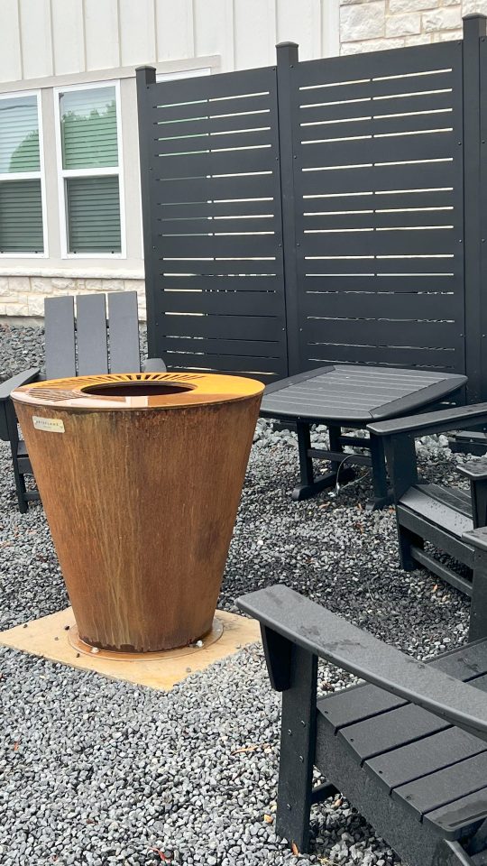 Apartments for Rent in Boerne, TX - Garden Creek Apartments - Fire Pit Area with Lounge Chairs on Top of Pebbles, and Manicured Greens