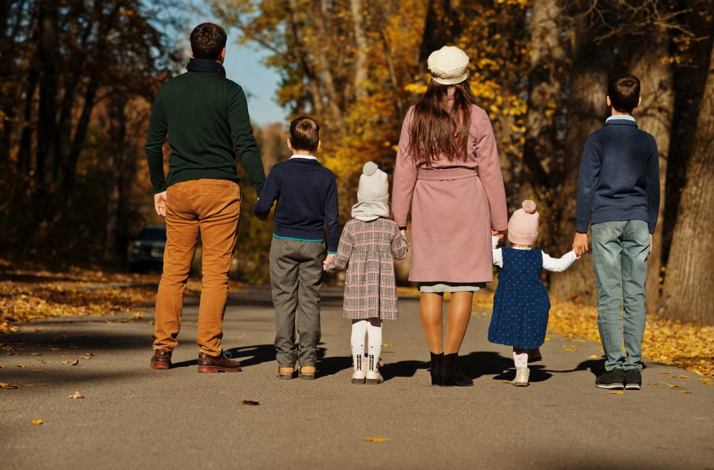a family walking down a road in the fall at The  Choir