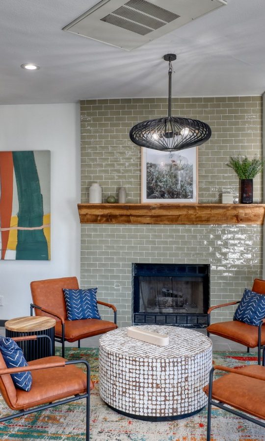 the living room features a fireplace, chairs and a television at The Jerome