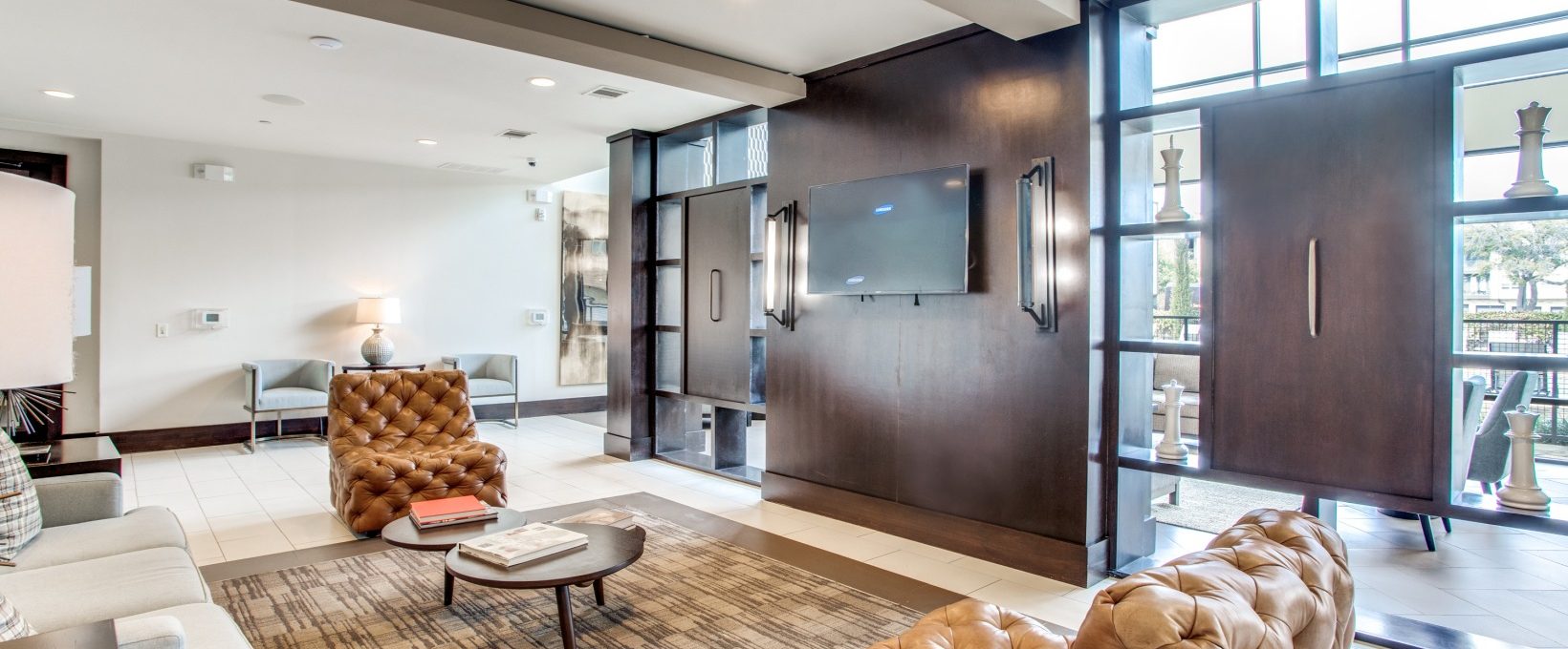 the living room has a large flat screen tv and leather furniture at The Live Oak at  Branch