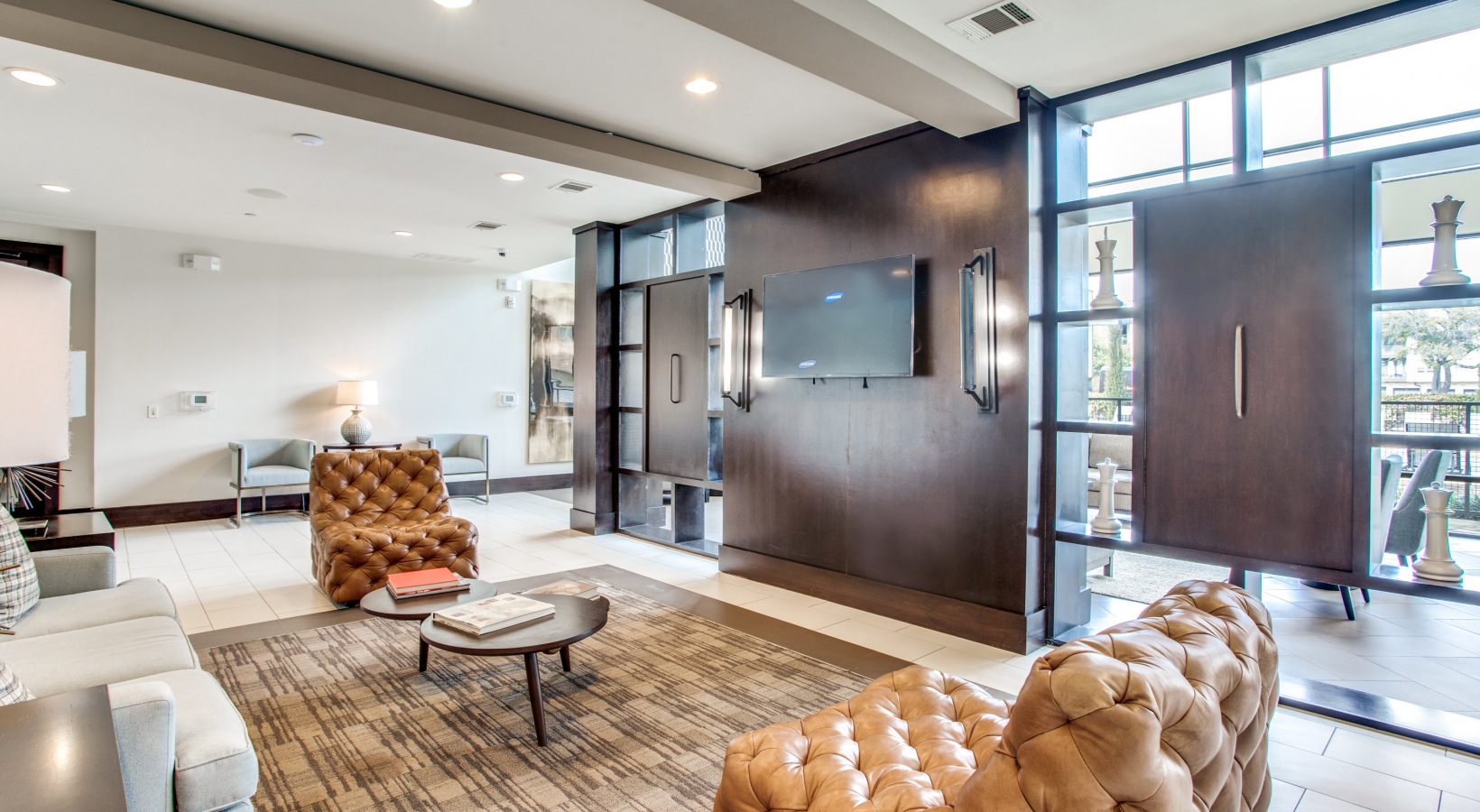 the living room has a large flat screen tv and leather furniture at The Live Oak at  Branch