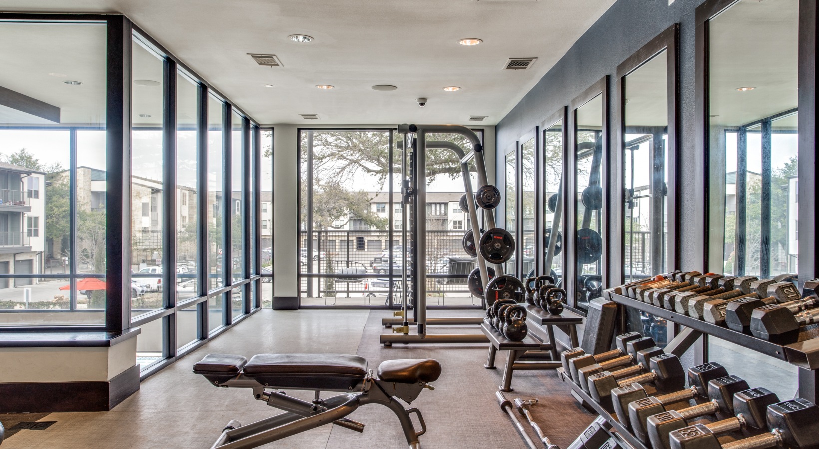 a gym room with a large window and a large mirror at The Live Oak at  Branch