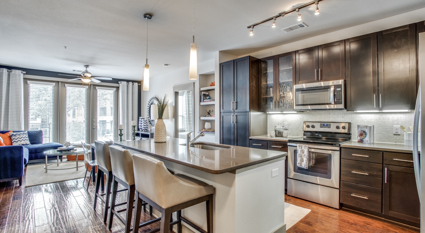 a kitchen with stainless steel appliances and wood floors at The Live Oak at  Branch