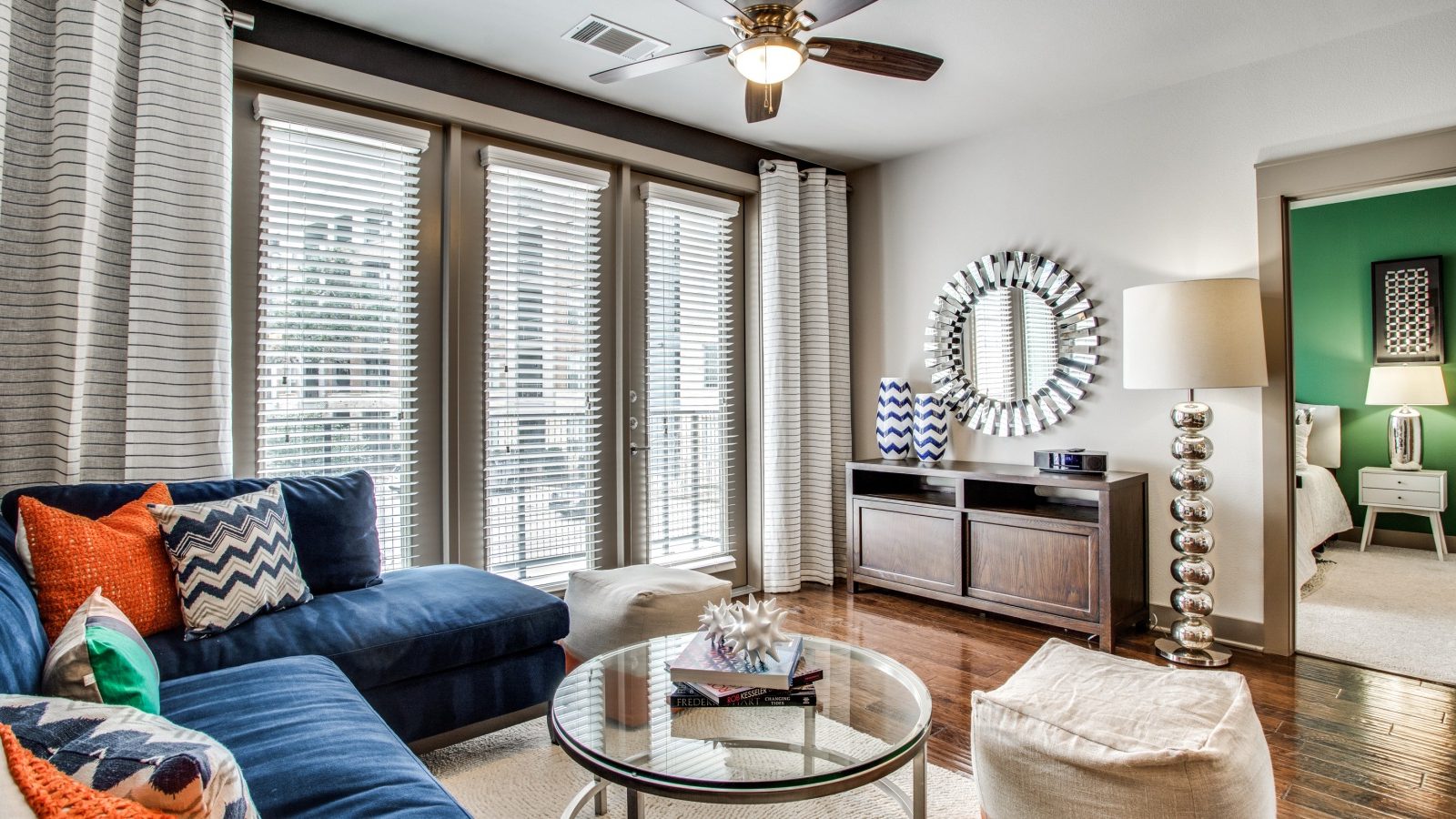 a living room with blue furniture and a large window at The Live Oak at  Branch