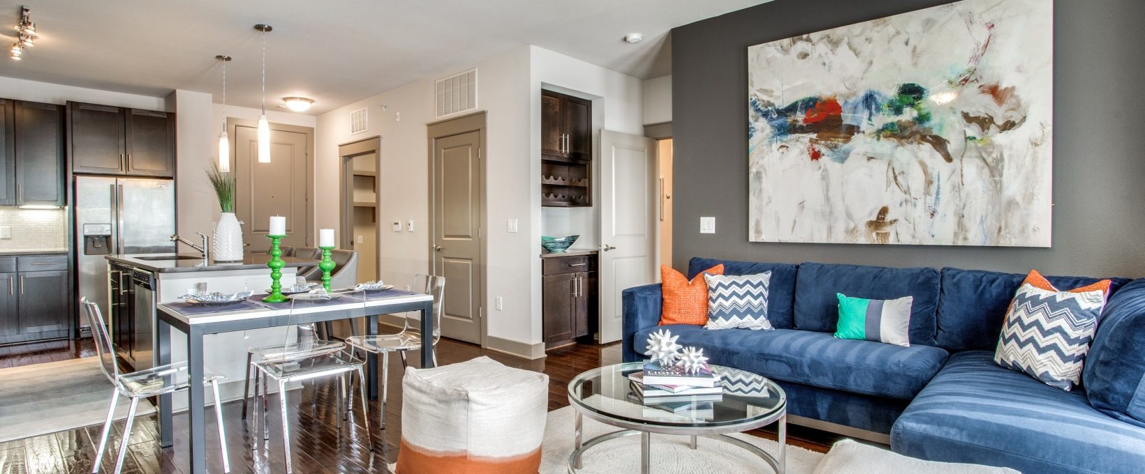 a living room with blue furniture and a large painting at The Live Oak at  Branch