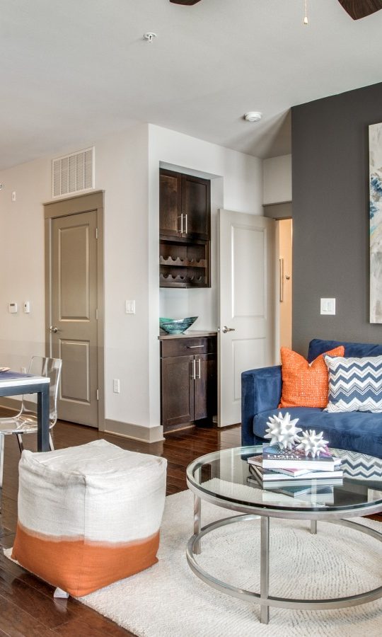 a living room with blue furniture and a large painting at The Live Oak at  Branch