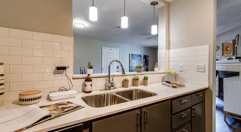 a kitchen with a sink, counter and light fixture at The Lorenzo